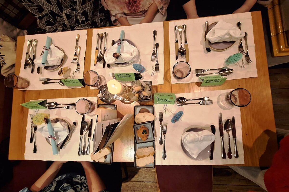 Tisch mit 5 Gedecken und Namenskärtchen, schön dekoriert.