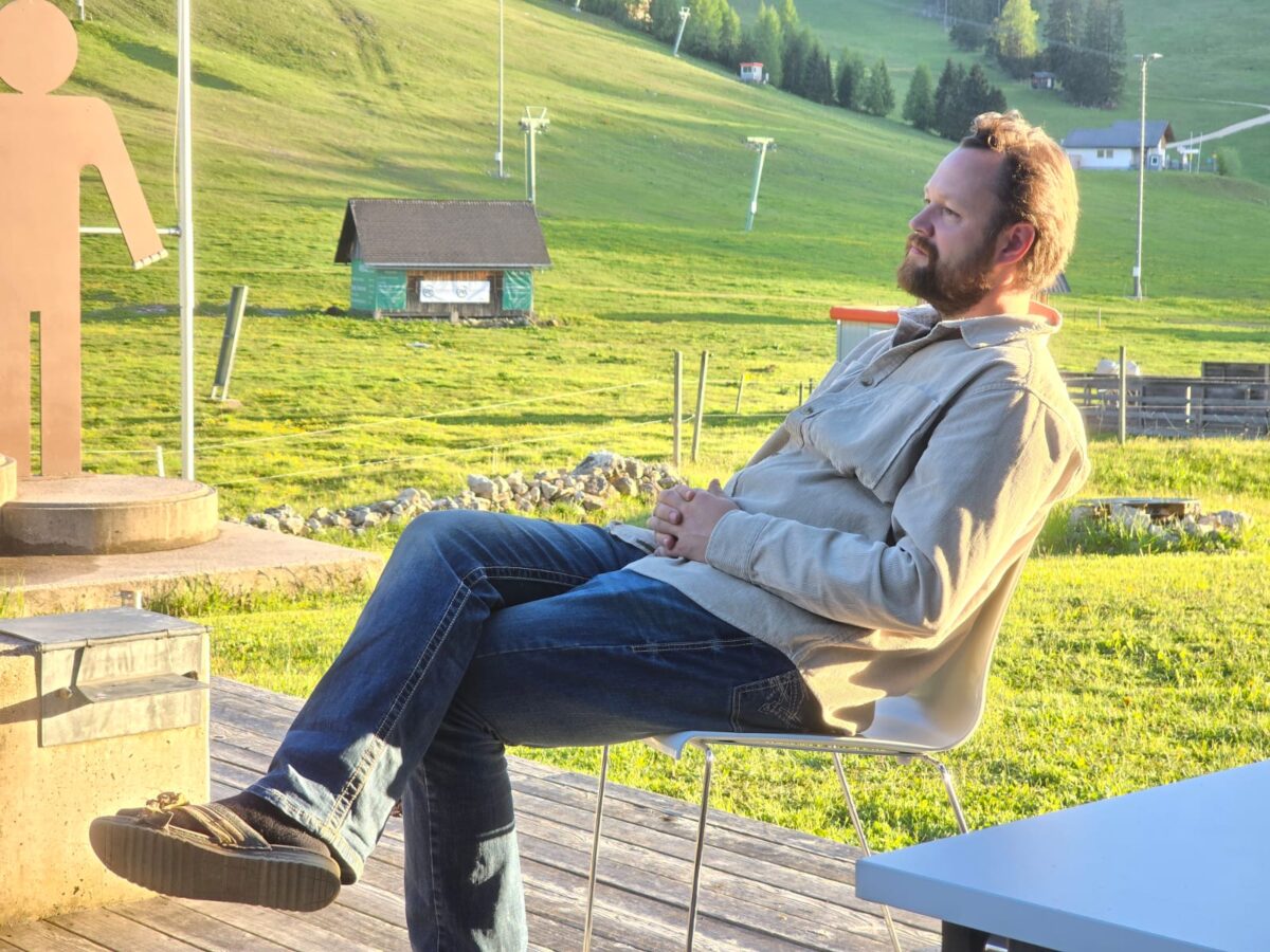 Ein Mann sitzt nachdenklich auf der Terrasse in einem Stuhl in der Natur