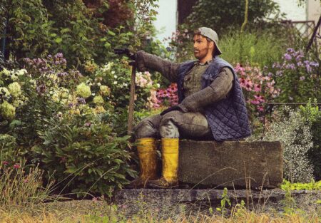 Frühlingsgarten mit einer Holzfigur, die als Gärtner gekleidet ist.