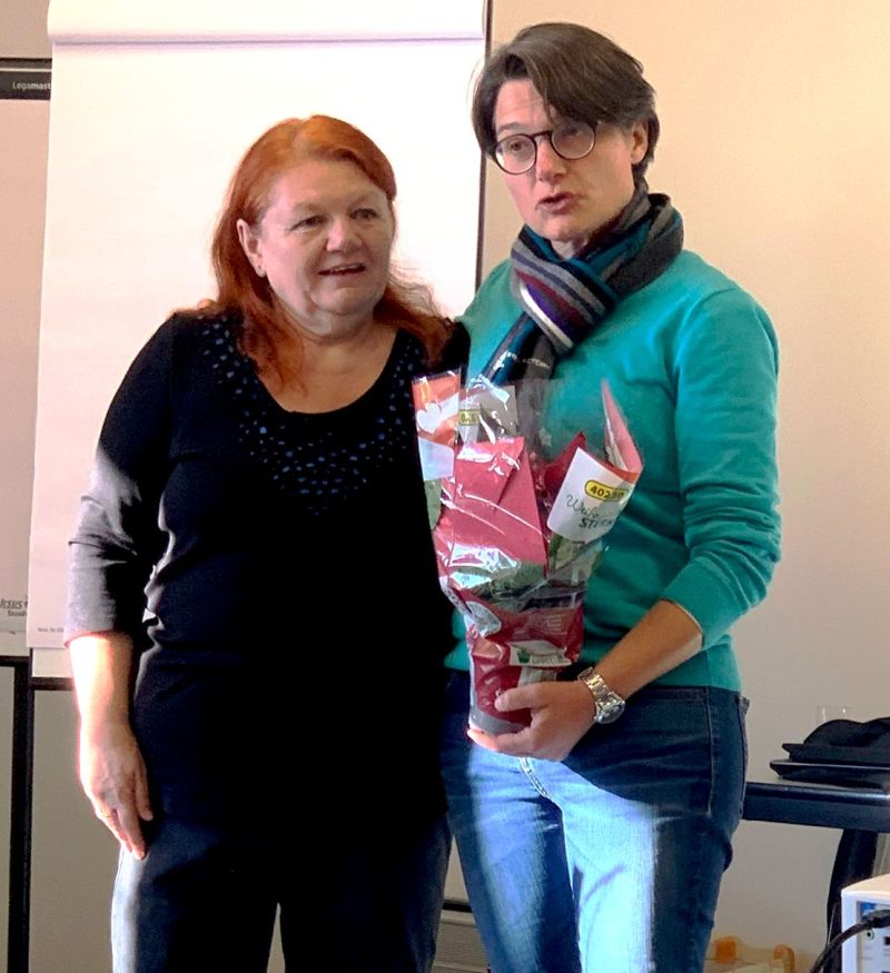 Der Seminarleiterin werden Blumen überreicht von einer Mitarbeitenden.
